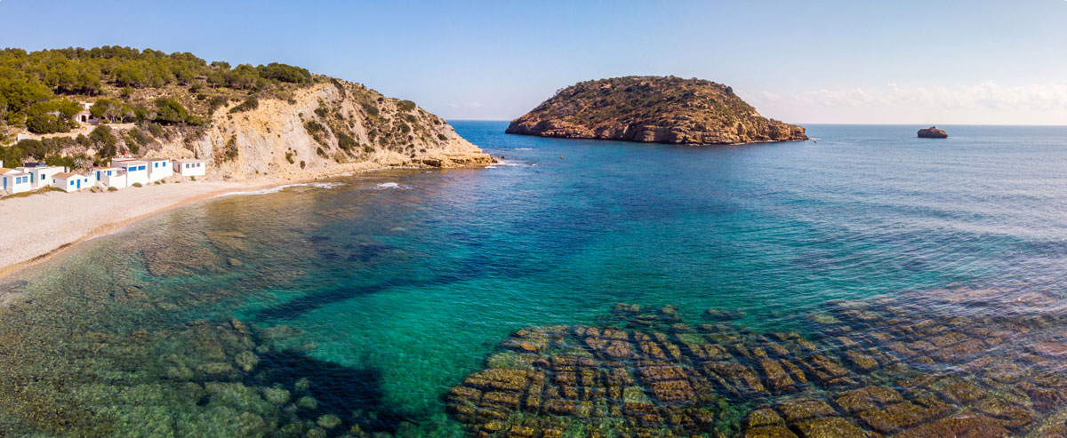 Dramatic limestone cliffs framing Cala del Portitxol